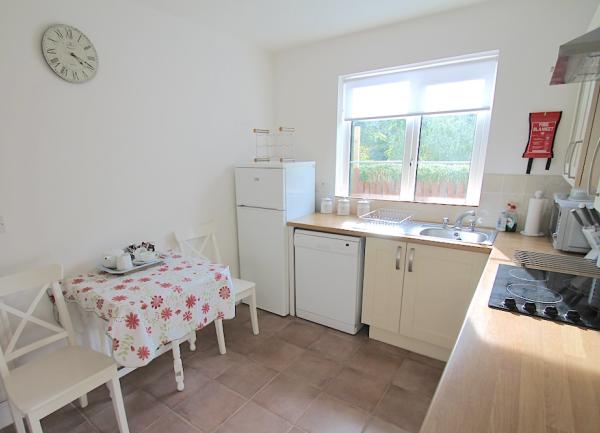 A country cottage kitchen with fitted units, oven, fridge-freezer and dishwasher
