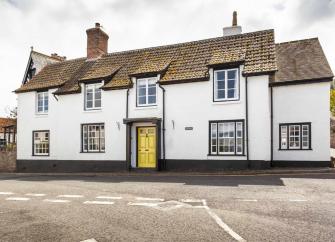 Double-fronted cottage exterior with traditional quarter-light windows.