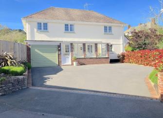 Double-fronted 2-storey Minehead holiday home with large drive and flower-filled borders.