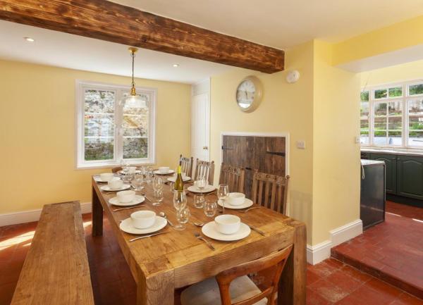Dining area with a chunky solid oak table and archway to a kiitchen.