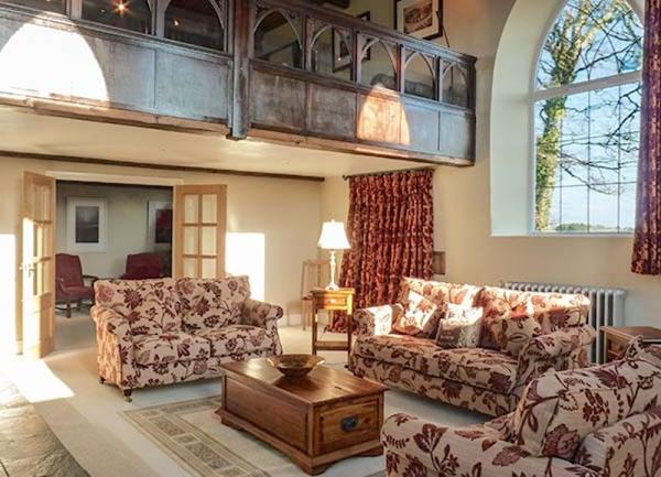 A large lounge with 3 sofas and a galleried landing.