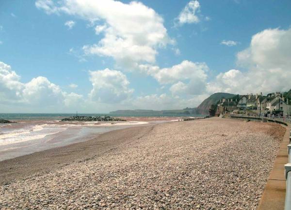 A curving East Devon pebble beach at low tide in Sidmouth.