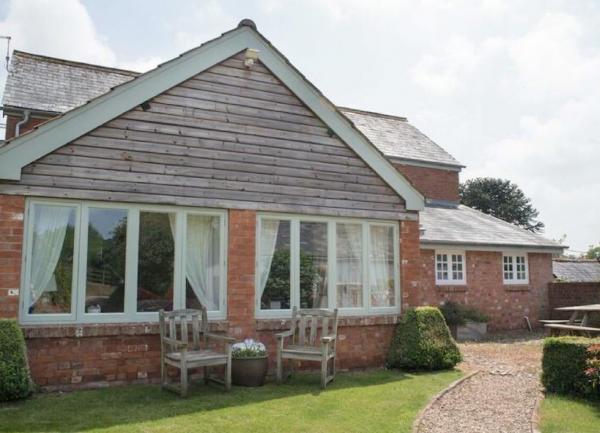  A single-storey gable end of a house with two rows of four windows overlooking a small lawn.