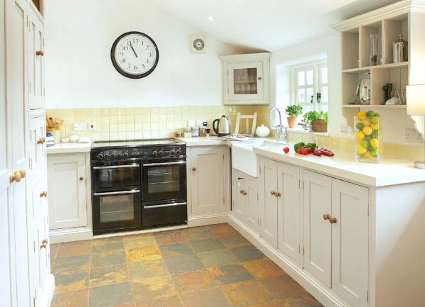 A fitted kitchen with cupboards on three walls with an integrated twin oven cooker.