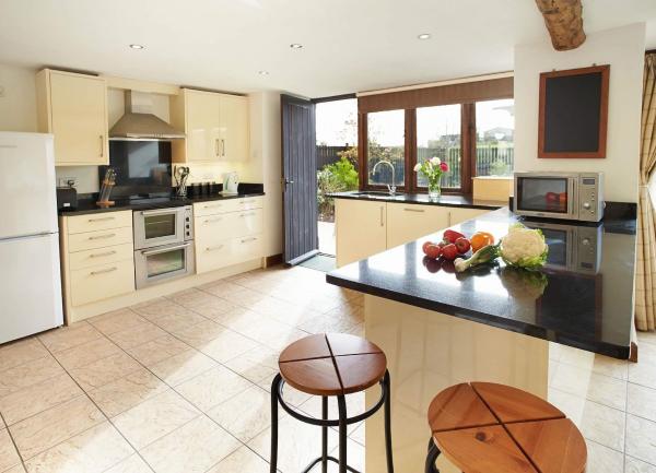 Spacious fitted kitchen with fitted units, white-goods, and breakfast bar