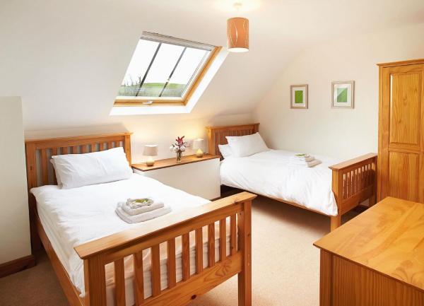 Twin bedroom with beds, bedside cabinet, wardrobe and chest-of-drawers.