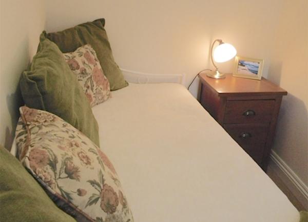 Single bedroom with a day bed. and bedside light.