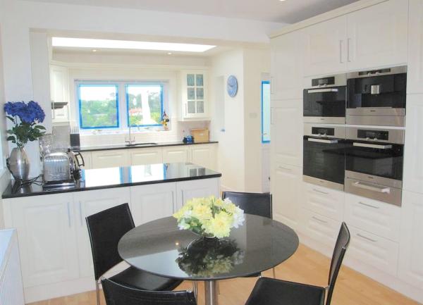 A kitchen-breakfast room with mid-height ovens and table for 4.