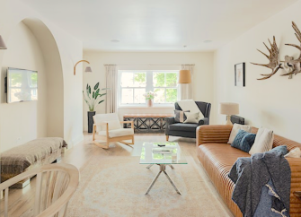 A luxuriously-furnished lounge with a wide-screen TV and a large leather sofa.