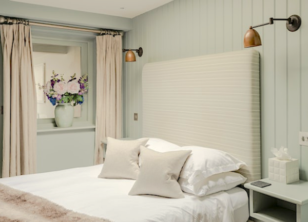 Double bedroom with bed, wall-mounted bedside shelves and lights.