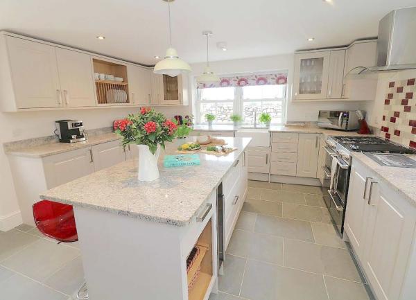 Modern fitted kitchen with a large Island block and integrated white-goods..