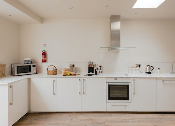 An L-shaped row of fitted kitchen units with integrated and worktop appliances.
