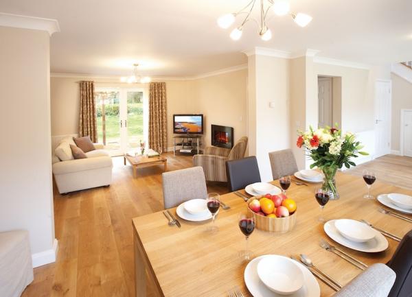 A. dining table laid for breakfast leads to a lounge area.