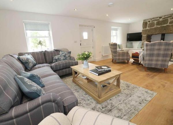 Spacious lounge with 2 sofas, 2 armchairs and inglenook fireplace.