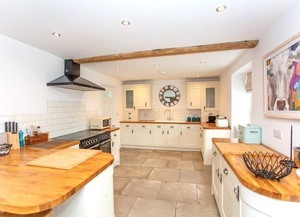 A luxury fitted kitchen with pine worktops range oven and integrated appliances.