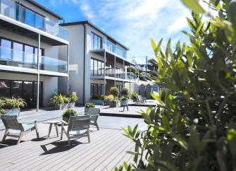 3-storey contemporary seaside apartment block with glass-screened balconies.