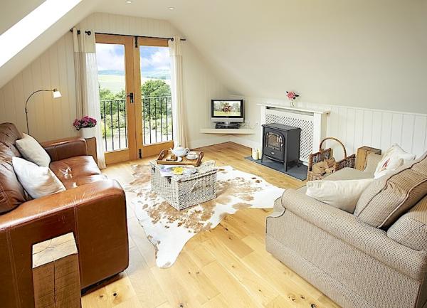  A lounge with comfortable seating and rural views in a luxury loft apartment.