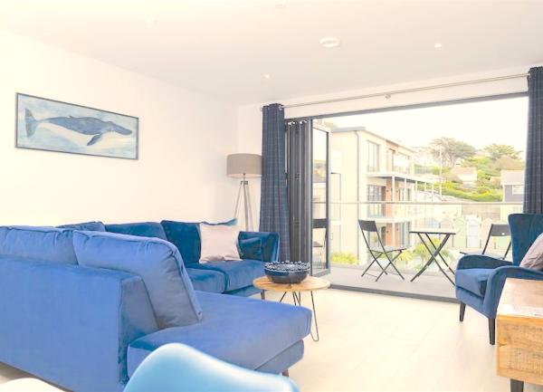 Seaside holiday apartment lounge with bi-fold doors to a balcony.