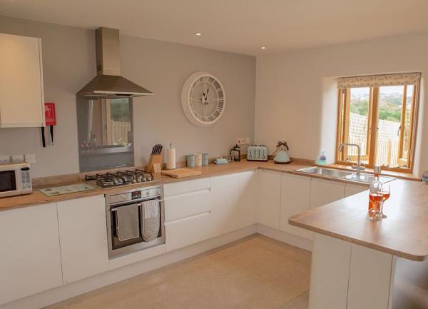 Spacious fitted kitchen with an integrated oven, microwave and worktop appliances.