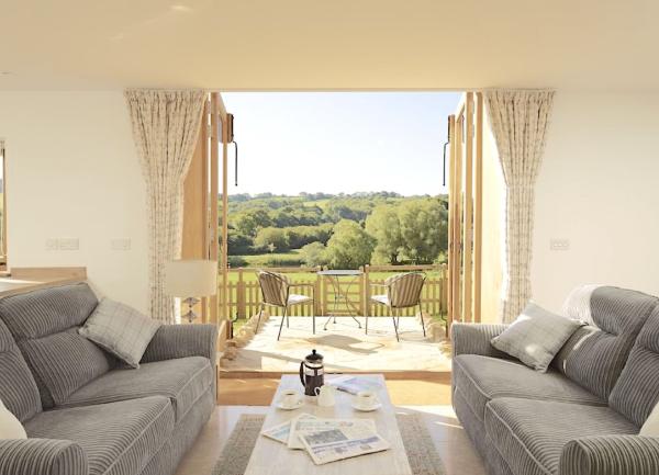 Lounge with twin sofas and French windows to a terrace with outdoor table seating and wonderful rural views,