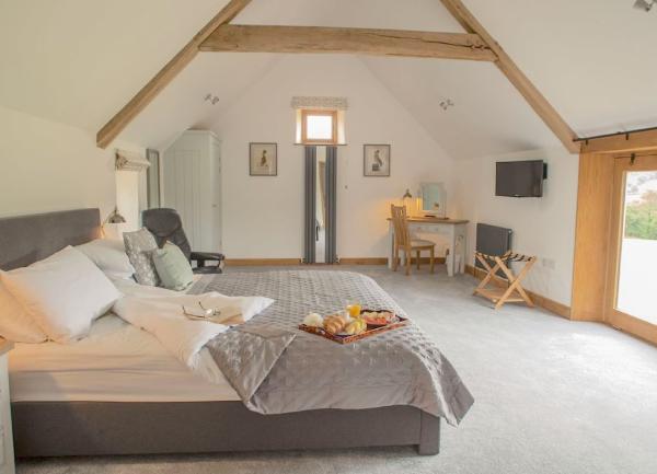 Double bedroom with bed, dressing table, TV and armchair.