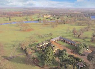 Aerial view of the flat Lincolnshire countryside with a group of luxury stable conversions surrounding a large courtyard.