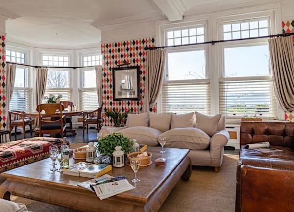 A big dual aspect lounge with 3 large leather sofas around a bed-sized coffee table.