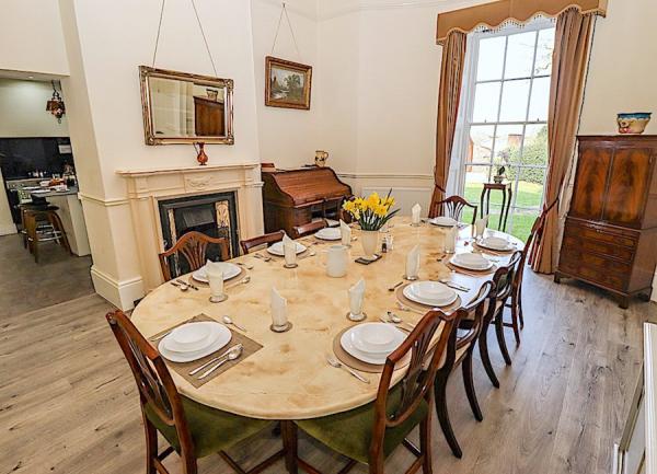 A formal dining room with a table and chairs seating ten..