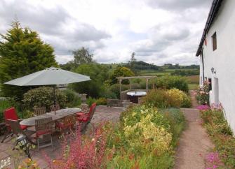 A flower-filled garden with rural views alongside a Somerset holiday cottage. 