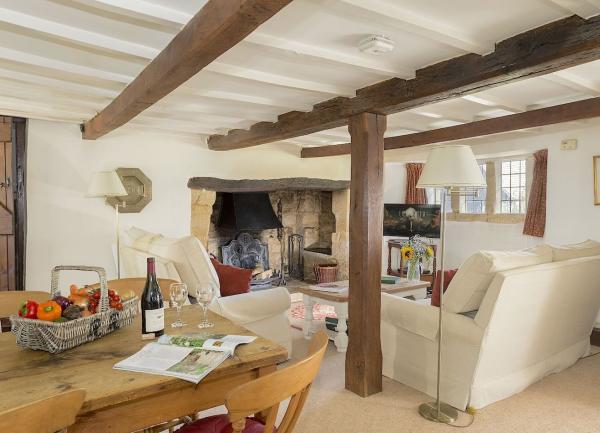 A lounge-dining area with oak beams and inglenook fireplace.