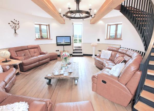 Sofas and a TV line the wall of a circular lounge in a windmill.