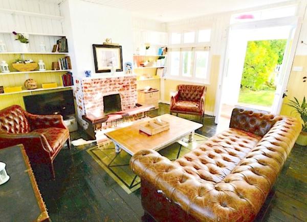 A wood-floored lounge with padded leather sofas, coffee table and TV.