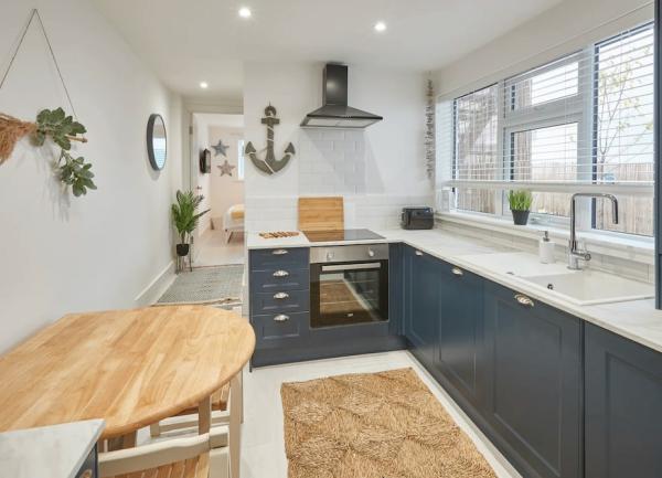 A stylish galley kitchen with fitted flor units, breakfast table and integrated appliances