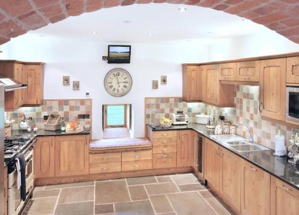 A fited kitchen with wll-mounted and floor cupboard on 3 sides of the room.