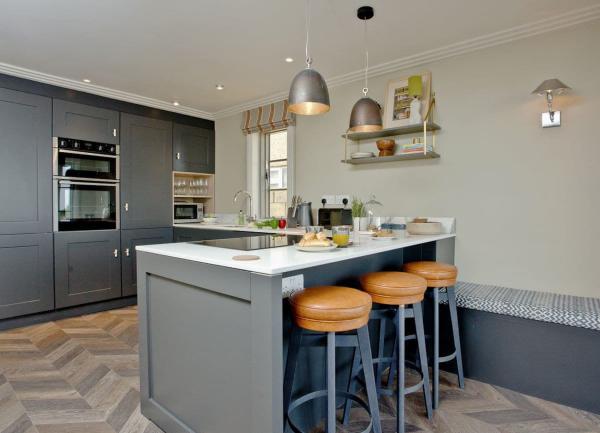 A contemporary kitchen with modern appliances and breakfast bar.