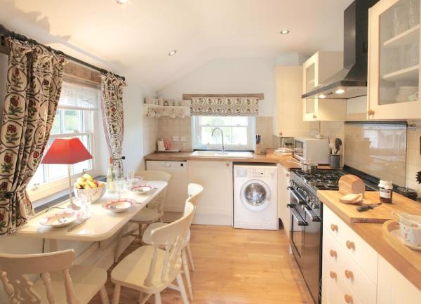 A Welsh cottage kitchen with fitted units, range cooker, washing machine and dining table for 6.