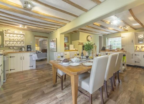 Spacious kitchen diner with fitted units on three sides and  dining table in the centre.