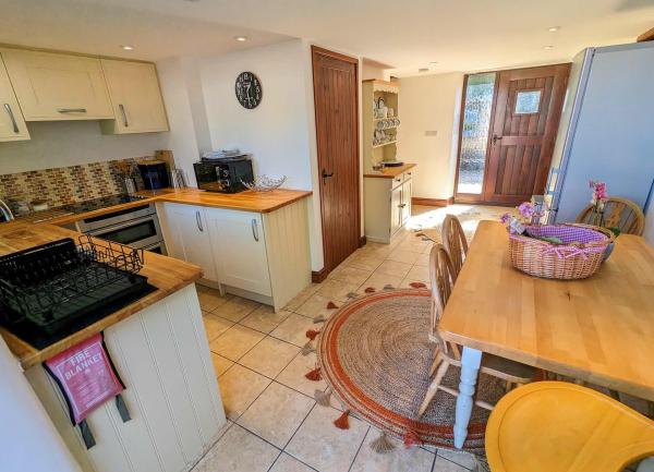Cottage kitchen with fitted units and a dining table.