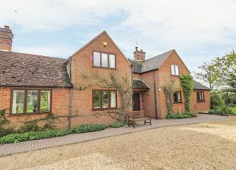 A twin-gabled brick holiay home overlooking a guest car-parking area