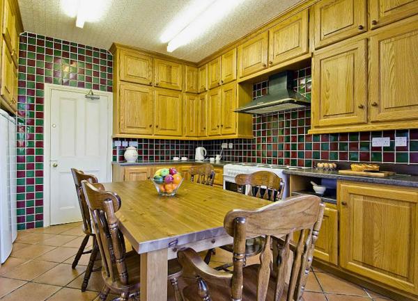 A large country house kitchen with 3 walls of floor and wall-mounted units and a breakfast table.