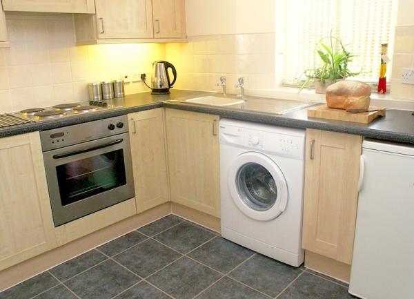 Fitted units ni a kitchen corner include a washing machine, oven ahd dishwasher.