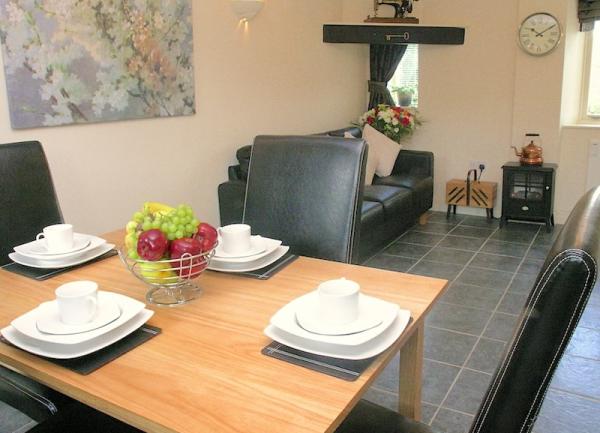 Dining area with a table and 4 padded leather chairs.