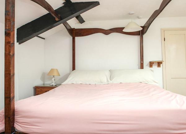 A double bedroom with a bedside table and a table lamp.