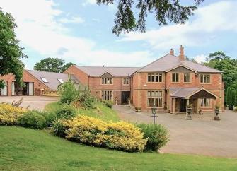 A large and rambling, brick-built country house and wing overlooks the Denbighshire countryside