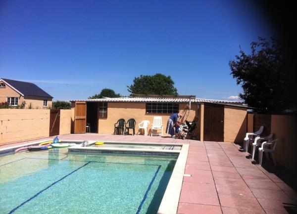 An outdoor swimming pool with chairs on the poolside terrace.