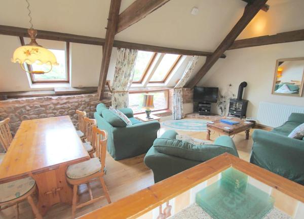 An open plan living areas with a sofa and armchairs facing a TV