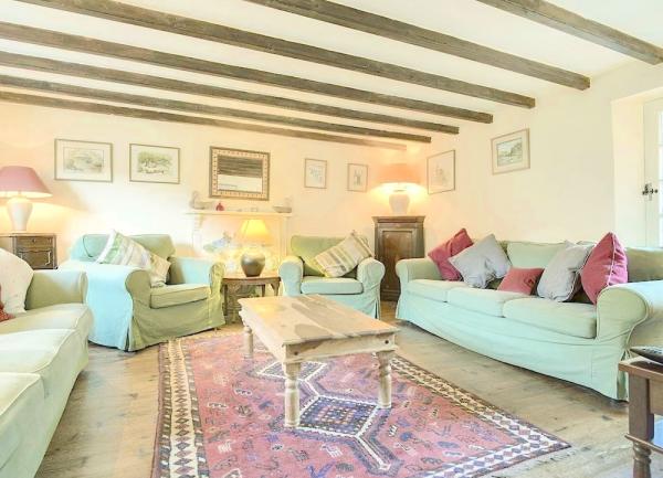 A farmhouse cottage lounge with a long wooden coffee table, matching sofas and armchairs.