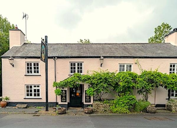 The Castle Inn at Lydford, Devon, a long 2-storey, wisteria-clad building.