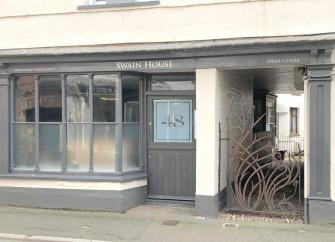 The entrance and front windows of the seaside shop converted into a holiday cottage.
