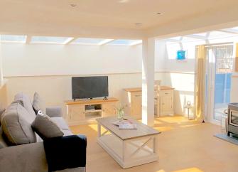 Interior of a spacious lounge with large roof lights in a Woolacombe holiday cottage.